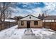 View of the backyard showcasing a brick home with a black front door and snowy front yard at 475 S Race St, Denver, CO 80209