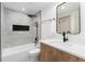 Modern bathroom with a sleek bathtub-shower combination, a wood vanity, and elegant marble tiling at 475 S Race St, Denver, CO 80209