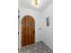 Inviting entryway with a unique patterned tile floor, an arched wood door, and modern lighting at 475 S Race St, Denver, CO 80209