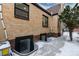 Tan brick house detail with egress window wells and snow-covered ground at 475 S Race St, Denver, CO 80209