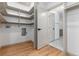 Bright laundry room features wood floors, white shelving, and modern utility connections at 475 S Race St, Denver, CO 80209