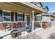 Covered front porch with brick accents, seating area and neutral colors at 17456 Quarry Way, Monument, CO 80132