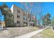 The brick apartment building sits on a rise with mature trees in front at 85 N Ogden St # 13, Denver, CO 80218