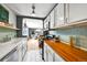 Bright kitchen showcasing stainless steel appliances, white cabinets, subway tile, butcher block counters, and hardwood floors at 85 N Ogden St # 13, Denver, CO 80218
