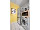 Laundry area featuring stainless steel refrigerator and washer and dryer on white tile floors against yellow wall at 85 N Ogden St # 13, Denver, CO 80218
