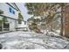 Snowy backyard with stone retaining wall and stairs leading to home at 2133 S Parfet Dr, Lakewood, CO 80227