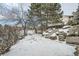 Landscaped backyard with stone steps and snowy ground at 2133 S Parfet Dr, Lakewood, CO 80227