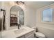 Modern bathroom with white vanity, black fixtures, and arched mirror at 2133 S Parfet Dr, Lakewood, CO 80227