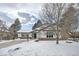 Snow-covered front yard of a remodeled midcentury modern home at 2133 S Parfet Dr, Lakewood, CO 80227