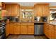 Modern kitchen featuring stainless steel appliances and wood cabinetry with tile backsplash at 32217 Buffalo Park Rd, Evergreen, CO 80439