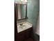Cozy half bathroom featuring a vanity with a classic framed mirror and natural light at 2477 S Oakland Cir, Aurora, CO 80014