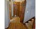Hallway with hardwood flooring, staircase, and closet space, ready for updates and personal touches at 2477 S Oakland Cir, Aurora, CO 80014
