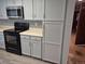 Kitchen with a black oven range, updated countertops, and light blue cabinets at 2477 S Oakland Cir, Aurora, CO 80014