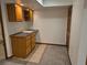 Basement kitchenette area with wood cabinets, countertop, tiled backsplash, and a sink for easy entertaining at 2477 S Oakland Cir, Aurora, CO 80014