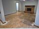 Living room with brick fireplace, open doorway, and new vinyl flooring at 2477 S Oakland Cir, Aurora, CO 80014