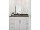 Bathroom with white cabinets, granite countertops, sleek hardware, and a large mirror at 928 Cimarron Dr # C, Lafayette, CO 80026