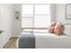 Comfortable bedroom with a large window, blinds, hardwood floors, and neutral decor at 928 Cimarron Dr # C, Lafayette, CO 80026