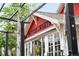 Unique restaurant exterior with a red building with white trim, signage, and treetop at 928 Cimarron Dr # C, Lafayette, CO 80026