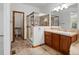 A well-lit bathroom featuring a glass-enclosed shower, vanity with wooden cabinets, and a toilet room at 7254 S Kellerman Way, Aurora, CO 80016