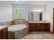A luxurious bathroom with a soaking tub, dual vanities, and natural light from a large window at 7254 S Kellerman Way, Aurora, CO 80016
