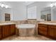 A luxurious bathroom with a soaking tub surrounded by decorative tile and wooden cabinets at 7254 S Kellerman Way, Aurora, CO 80016