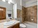 A tiled bathroom with a vanity, medicine cabinet, toilet, and a shower-tub combination at 7254 S Kellerman Way, Aurora, CO 80016