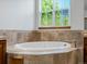 A luxurious bathroom with a soaking tub surrounded by decorative tile and wooden cabinets at 7254 S Kellerman Way, Aurora, CO 80016