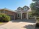 Charming two-story home featuring stone accents, dormer windows, and a welcoming front porch at 7254 S Kellerman Way, Aurora, CO 80016