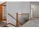 Hallway with stairs, wood banister, neutral walls, and carpets at 7254 S Kellerman Way, Aurora, CO 80016