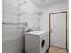 Well-lit laundry area with washer, dryer, shelving, and a tiled floor at 7254 S Kellerman Way, Aurora, CO 80016