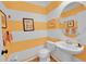 Charming powder room featuring yellow striped wallpaper and an oval mirror at 7064 E 2Nd Ave, Denver, CO 80220