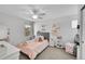 Bedroom with grey tufted headboard and vanity with decorative accents and ceiling fan at 7064 E 2Nd Ave, Denver, CO 80220