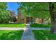 Inviting brick home with a well-manicured lawn and mature trees, creating a welcoming curb appeal at 7064 E 2Nd Ave, Denver, CO 80220