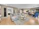 Open-concept living area with a comfortable sofa, hardwood floors, and seamlessly connected dining space at 7064 E 2Nd Ave, Denver, CO 80220