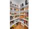 Organized pantry with white shelves stocked with various food items and kitchen appliances at 7064 E 2Nd Ave, Denver, CO 80220