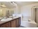 Bathroom featuring a double vanity, a bathtub, and a glass-enclosed shower at 821 Stony Mesa Pl, Castle Rock, CO 80108