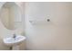 Bathroom featuring a pedestal sink, large oval mirror and chrome towel bar at 821 Stony Mesa Pl, Castle Rock, CO 80108