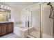 Bathroom featuring a double vanity, a bathtub, and a glass-enclosed shower at 821 Stony Mesa Pl, Castle Rock, CO 80108