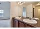 Bathroom featuring a double vanity with chrome fixtures and a large mirror at 821 Stony Mesa Pl, Castle Rock, CO 80108