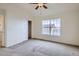 Empty bedroom with neutral carpet, ceiling fan, and a window letting in natural light at 821 Stony Mesa Pl, Castle Rock, CO 80108