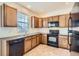 Functional kitchen featuring oak cabinets, black appliances, and tile flooring at 821 Stony Mesa Pl, Castle Rock, CO 80108