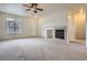 Spacious living room featuring a ceiling fan, fireplace, neutral carpet, and bright natural light at 821 Stony Mesa Pl, Castle Rock, CO 80108