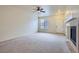 Bright living room with neutral carpeting, fireplace, ceiling fan, and open access to other rooms at 821 Stony Mesa Pl, Castle Rock, CO 80108