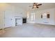 Bright living room with neutral carpeting, fireplace, ceiling fan, and open access to other rooms at 821 Stony Mesa Pl, Castle Rock, CO 80108