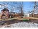 Backyard featuring a playset with partial snow coverage and sparse landscaping at 1599 W Beekman Pl, Denver, CO 80221