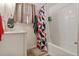 Bright bathroom featuring a shower and tub, white cabinets and a tiled accent wall at 1599 W Beekman Pl, Denver, CO 80221