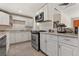 Galley kitchen features white cabinets, stainless steel appliances, and granite countertops at 1599 W Beekman Pl, Denver, CO 80221