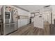 Spacious kitchen with stainless steel appliances, white cabinets, and wood flooring at 1599 W Beekman Pl, Denver, CO 80221