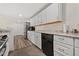 Well-lit kitchen with white cabinets, stainless steel appliances and wood-look flooring at 1599 W Beekman Pl, Denver, CO 80221