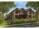 Charming two-story home with a brick facade, manicured lawn and a beautiful garden area surrounded by a wrought iron fence at 343 S Gaylord St, Denver, CO 80209